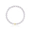 un bracelet en perles blanches avec un fermoir en or