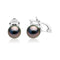 gros plan sur une paire de boucles d’oreilles en perles noires et diamants