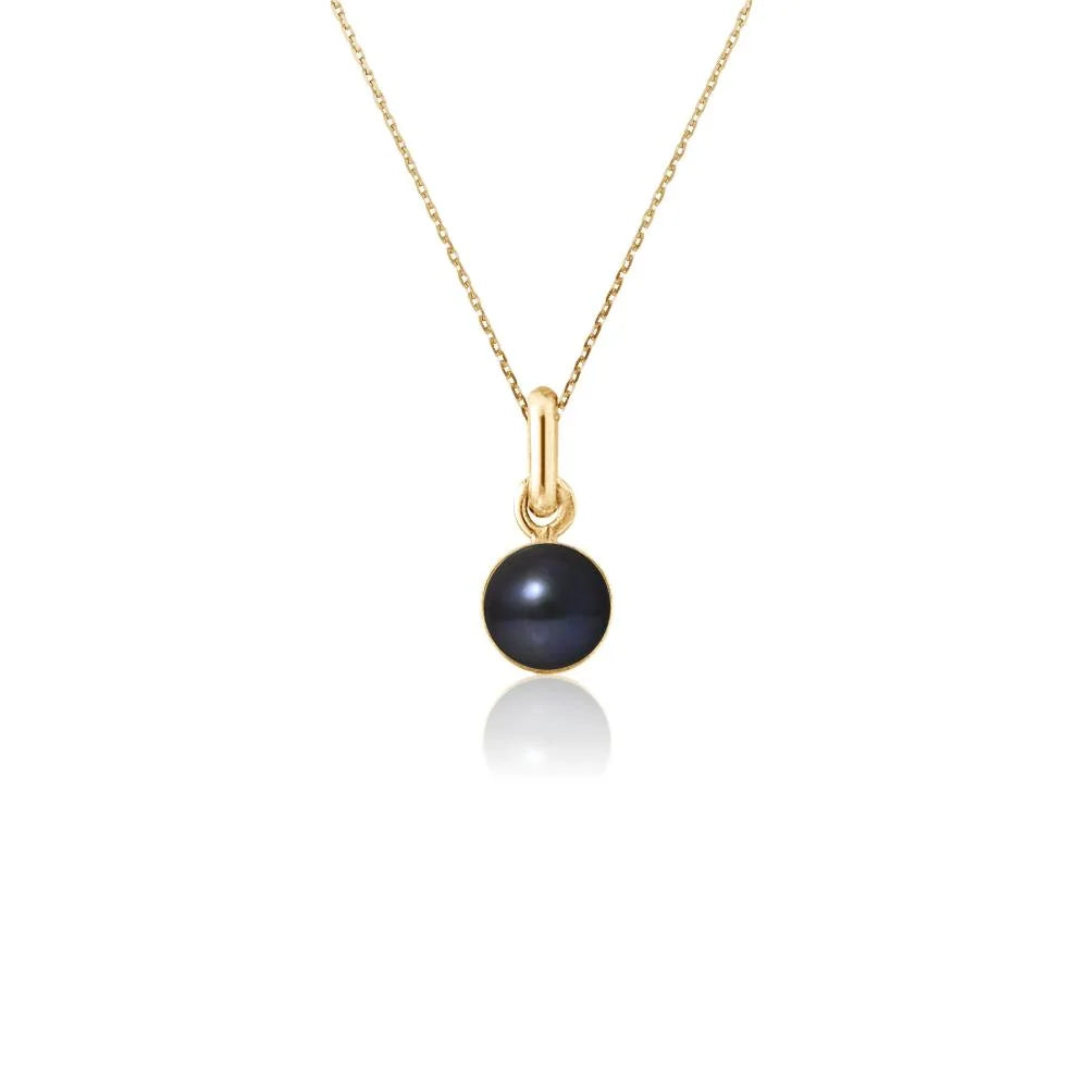 un collier en or avec une perle noire